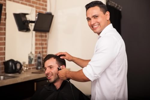 A Barber Trimming a Client's Sideburns
