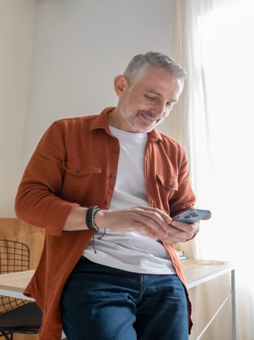A Man Booking an Appointment at his barber by Mobile Phone